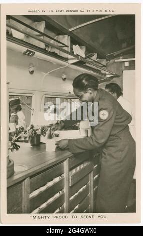 Une carte postale de volontaires afro-américains dans un "Clubmobile" de la Croix-Rouge servant du café aux militaires américains. Le texte au-dessus de l'image se lit comme suit: [PASSÉ PAR le CENSEUR de l'ARMÉE des États-Unis no 21 E. T. O., U. S. A.], et le texte au-dessous de l'image lit» ["PUISSANT FIER DE VOUS SERVIR]. Le verso de la carte postale comporte un marquage de carte postale pré-imprimé à l'encre brune qui comprend la section correspondance, la section adresse, la section cachet et des informations sur l'envoi de la carte postale. La carte postale n'est pas utilisée. Banque D'Images