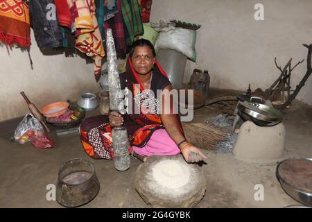 TRIBU KOL. Une femme piquant le grain dans le mortier traditionnel et le broyeur de pilon. Bhanpur Village de Huzur Tehsil à Rewa Dist, Madhya Pradesh, Inde Banque D'Images