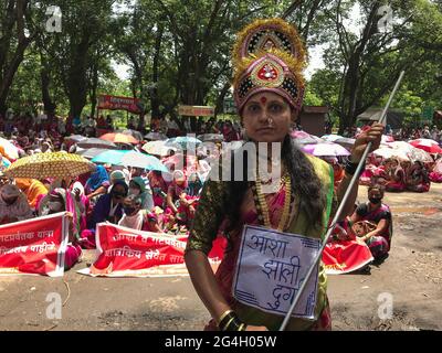 Kolhapur, Maharashtra, Inde. 21 juin 2021. Un travailleur de l'ASHA est habillé comme une déesse pour tuer le coronavirus. Plus de 2000 travailleurs de l'ASHA ont protesté aujourd'hui au bureau du magistrat de district de Kolhapur pour leurs trois mois en attendant le salaire et d'autres demandes. Les travailleurs de la santé accrédités (ASHA) sont des travailleurs de première ligne dans cette pandémie. Ces personnes courageuses sont surchargées de tâches non COVID et COVID. Ils risquent leur vie avec des équipements de sécurité inadéquats et seulement 33 INR comme incitatif COVID quotidien. Les soixante-dix mille travailleurs de l'ASHA du Maharashtra sont en grève pour une durée indéterminée pendant les sept derniers jours Banque D'Images