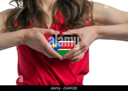 Amour Sud Soudan. La femme tient un coeur sous la forme du drapeau du Sud Soudan sur sa poitrine. Concept de patriotisme. Banque D'Images