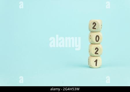 Quatre cubes de jouets en bois disposés en vertical sur fond bleu avec le texte 2021, la croissance de l'entreprise et le concept de gestion Banque D'Images