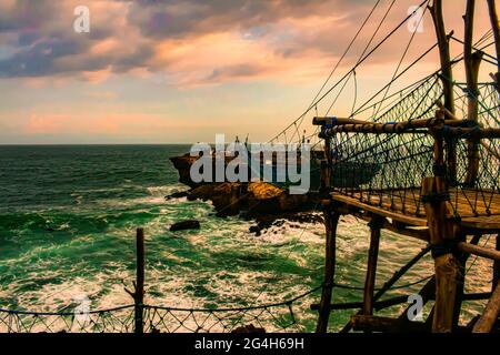 Défi sur le pont de pied de corde balançoire et le téléphérique à une île de roche avec de grandes vagues dangereuses à la plage de Pantai Timang, Java, Indonésie Banque D'Images