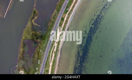 Une autoroute qui longe une étroite broche entre la mer et l'estuaire. Voitures sur la route. Vue aérienne. Banque D'Images