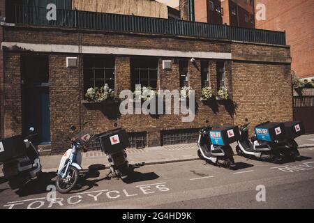 Vauxhall, Londres | Royaume-Uni - 2021.06.13 : scooters de livraison garés sur le côté le jour ensoleillé à l'ouest de Londres Banque D'Images