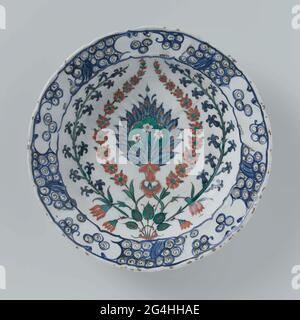 . Quartz Fritgoed avec un plat de plomb décoré d'une plante à fleurs stylisée en bleu, rouge, noir et vert sur blanc sous un vernis transparent plomb-alakali-tinglacer. Iznik. Banque D'Images