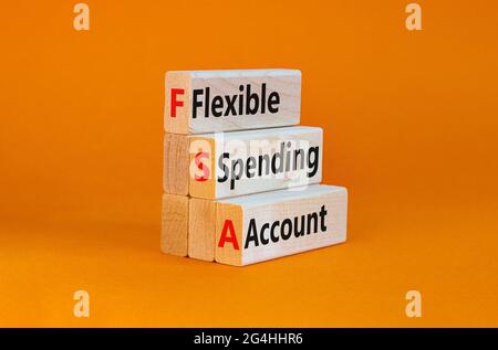 Symbole de compte de dépenses flexible FSA. Concept mots FSA flexible compte de dépenses sur des blocs de bois sur un beau fond orange. Business et FSA Banque D'Images