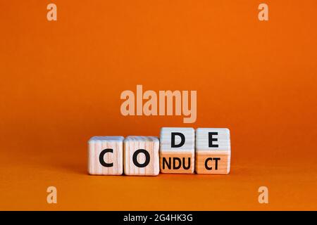 Symbole du code de conduite. A tourné le cube en bois et a changé le mot code pour conduire. Magnifique arrière-plan orange. Concept d'entreprise et de code de conduite Banque D'Images