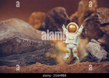 Fier astronaute qui célèbre en levant les bras sur une montagne rocheuse. Spaceman porte un costume blanc et un casque. Concept de cosmonautics, Banque D'Images