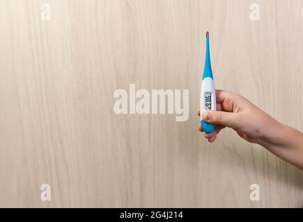 Un thermomètre électronique dans la paume de votre main. Démonstration de la température corporelle normale en degrés Fahrenheit. Banque D'Images