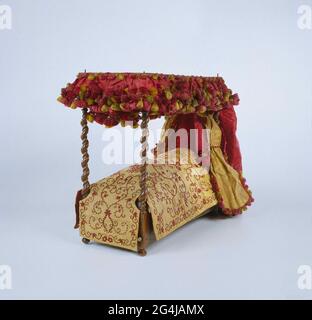 . Lit amusant, en noyer, complètement rigé avec des rideaux et des chutes de soie. Le lit se compose d'une poubelle en bois avec tête de lit surélevée, reposant sur les jambes de bol, dans laquelle une construction est imitée avec de fausses charnières, comme si les deux côtés longs peuvent être repliés. Dans la poubelle se trouve un fond meuble, composé d'un cadre en chêne avec des pneus rouges blancs quadrillés contour. Les styles de coin carré avec des boulons de berceau imitation, marcher dans quatre styles de lit double-torsadé, sur lequel le ciel et le cadre reposent avec l'extérieur tombe sur quatre broches de fer. Quatre tiges sont disposées entre les styles auxquels trois m rouges Banque D'Images