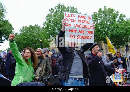 Un homme tient un écriteau appelant à un débat sur les vaccins Covid-19, alors que les manifestants protestent contre la « Journée de la liberté » qui a été retardée. Banque D'Images