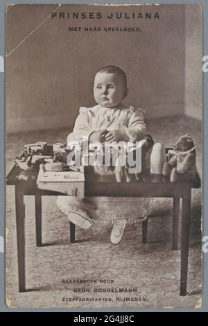 Princesse Juliana avec ses jouets. Carte postale avec portrait de princesse juliana assis devant une table avec des jouets. Offert par Gebr. Dobbelmann, fabricant de savon, Nimègue. Banque D'Images