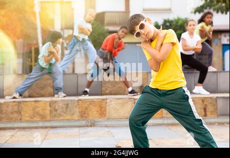 Danseuse de hip hop Tween boy qui se interprète avec un groupe dans la rue de la ville Banque D'Images