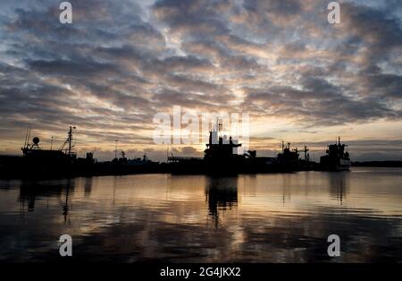 Kiel, Allemagne. 22 juin 2021. Le soleil se lève tôt le matin au-dessus du port naval du fjord de Kiel entre quelques nuages. Credit: Axel Heimken/dpa/Alay Live News Banque D'Images