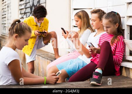 Enfants jouant sur smartphone outdoors Banque D'Images