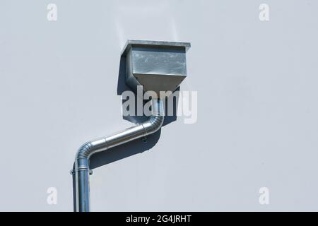 Nouvelle tête de conducteur d'eau de pluie galvanisée et bec verseur incliné installé sur le mur du bâtiment. Banque D'Images