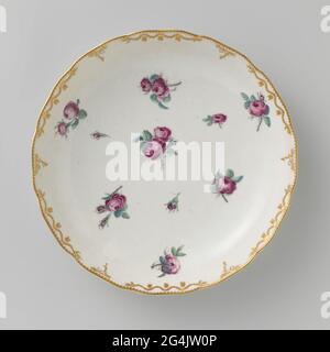 Écaillé, peint avec des roses éparses. Echelle de porcelaine. Bordure festonnée avec motifs rumeur en relief, qui sont partiellement plaquées, partiellement recouvertes de guirlandes de feuilles en or. Les Bies avec feuilles dépendantes travaillent en or sur le bord. Peint avec des roses éparses dans la rose, le vert, le bleu et le gris. Banque D'Images