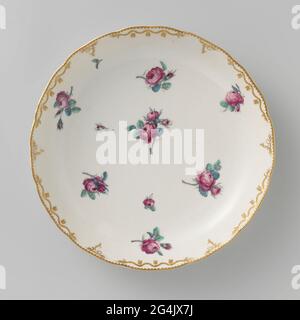 Écaillé, peint avec des roses éparses. Echelle de porcelaine. Bordure festonnée avec motifs rumeur en relief, qui sont partiellement plaquées, partiellement recouvertes de guirlandes de feuilles en or. Les Bies avec feuilles dépendantes travaillent en or sur le bord. Peint avec des roses éparses dans la rose, le vert, le bleu et le gris. Banque D'Images