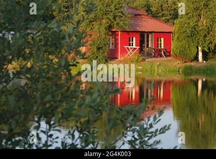 Joli petit chalet de vacances rouge sur le lac en France Banque D'Images