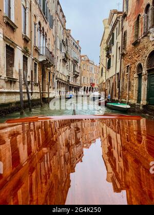 Elle abrite des réflexions sur la cagoule en bois verni, ponton, du bateau-taxi dans les rues de Venise, qui part Banque D'Images