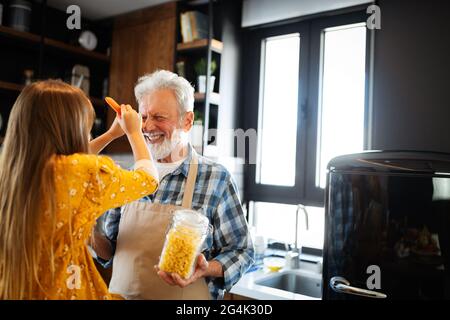 Grand-père souriant d'aider les enfants à cuisiner dans la cuisine Banque D'Images