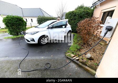 Voiture électrique Renault Zoe. Une femme charge la batterie de son véhicule à la maison Banque D'Images