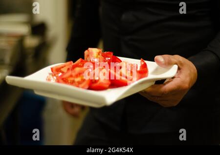 Petit foyer d'un serveur servant des tomates dans un restaurant Banque D'Images