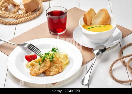 Soupe à la crème de pois, purée de pommes de terre avec filet de poulet frit et compote de baies Banque D'Images