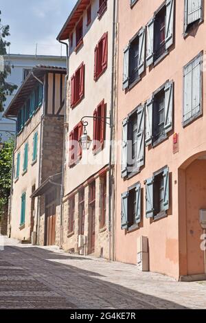 Un mélange de maisons d'infill médiévales et modernes rénovées sur la rue du Pont-St Etienne, menant à la porte d'origine dans le mur de la ville de Limoges, en France Banque D'Images