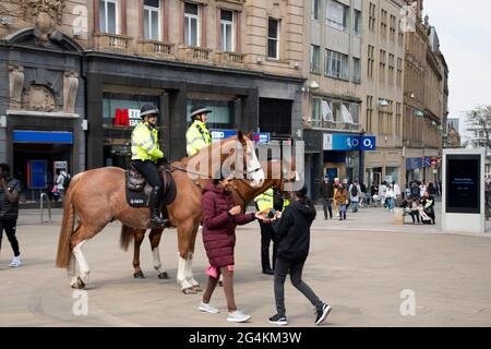 Sheffield Royaume-Uni: 17 avril 2021: Aux femmes prendre avec joie des photographies posant avec les chevaux de police dans le centre ville de Sheffield, Fargate Banque D'Images