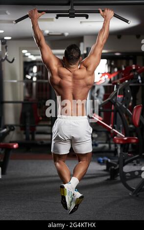 Homme faisant des exercices dans la salle de fitness au bar Banque D'Images