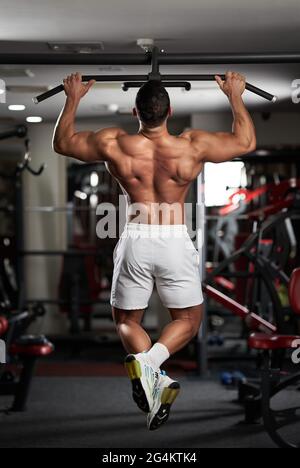 Homme faisant des exercices dans la salle de fitness au bar Banque D'Images