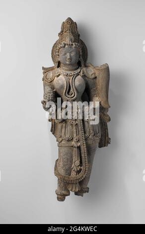 . Le corps de cette beauté céleste (apsara) est chargé de bijoux, qui a été méticuleusement sculpté. Ceci est caractéristique de la période au cours de laquelle la sculpture a été faite, pendant le règne de la dynastie Hoysala (11ème-14ème siècle). Les murs extérieurs des temples de Hoysala sont presque entièrement couverts de sculptures, et cette figure aurait fait partie de la somptueuse décoration à l'extérieur d'un tel temple. Banque D'Images