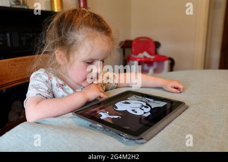 Enfant fille regardant la vidéo sur Apple iPad tablette à la maison. Tablette ordinateurs ordinateur enfants tout-petits jeune appareil électronique numérique écran Grande-Bretagne Banque D'Images