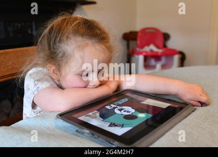 Enfant fille regardant la vidéo sur Apple iPad tablette à la maison. Tablette ordinateurs ordinateur enfants tout-petits jeune appareil électronique numérique écran Grande-Bretagne Banque D'Images