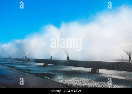 Fontaines d'un système de tuyaux d'eau de refroidissement à une centrale thermique. Fontaine éclabousse contre le ciel bleu dans la zone industrielle. Banque D'Images