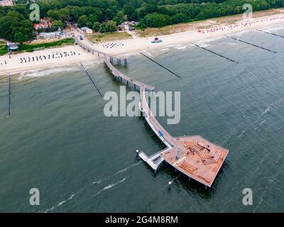 23 juin 2021, Mecklembourg-Poméranie occidentale, Koserow: Vue sur le nouveau quai dans la station Baltique de Koserow sur l'île d'Usedom (photographie aérienne prise par drone). La structure, qui s'étend sur environ 280 mètres dans la mer et comprend une jetée, une rampe et une plate-forme, a été construite sur 67 piles de fondation. Le nouveau quai a coûté un peu moins de 7.4 millions d'euros, avec environ 4.9 millions d'euros provenant du ministère des Affaires économiques. De plus, un clocher de huit mètres de haut a été installé sur la tête de l'embarcadère, ainsi qu'un coin salon et bain de soleil. À la fin du mois de juin, le quai sera temporaire Banque D'Images