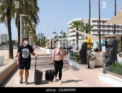 Les touristes portent leurs bagages par Magaluf front de mer, Mallorca, Espagne, comme les îles Baléares sont sur le point d'être ajouté à la liste verte de voyage. Banque D'Images