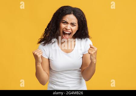Émotions, folie et concept de personnes. Une femme noire en colère crie et clame ses poings, prête à se battre Banque D'Images