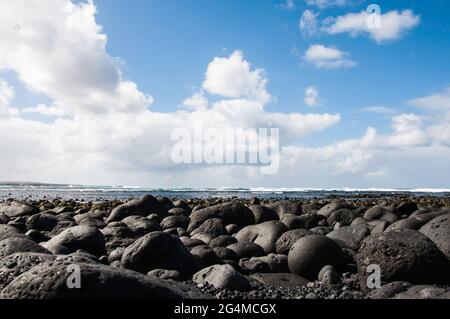 Îles Canaries, Lanzarote ,. Côte avec des roches de lave noires et refroidies typiques qui ont été polies au fil du temps Banque D'Images