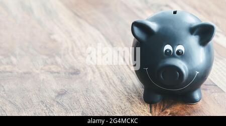 banc de porc noir sur table en bois avec espace de copie sur le côté gauche Banque D'Images
