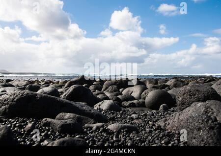 Îles Canaries, Lanzarote ,. Côte avec des roches de lave noires et refroidies typiques qui ont été polies au fil du temps Banque D'Images