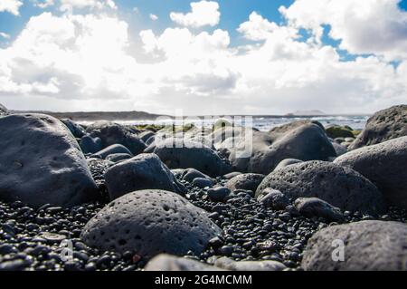 Îles Canaries, Lanzarote ,. Côte avec des roches de lave noires et refroidies typiques qui ont été polies au fil du temps Banque D'Images