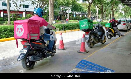 Cebu City, Philippines ; 22 juin 2021 -- scène pandémique commune d'un chauffeur de livraison de nourriture se dépêchant d'apporter de la nourriture commandée à un client dans cette ville. Banque D'Images