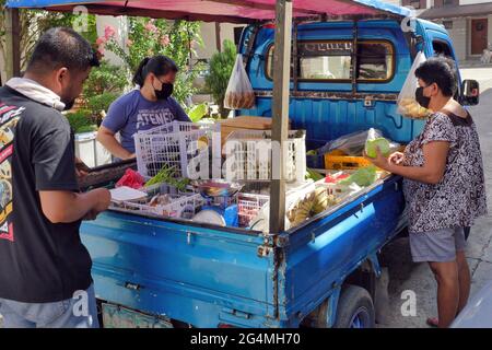 Cebu City, Philippines ; 21 juin 2021 -- des résidents de la subdivision pendant la pandémie achetaient des fruits et des légumes à un vendeur itinérant dans son véhicule. Banque D'Images