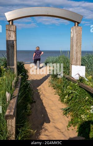 Une femme blonde aime marcher sur la plage de sable lors d'une chaude journée d'été à Mablethorpe, Lincolnshire Banque D'Images