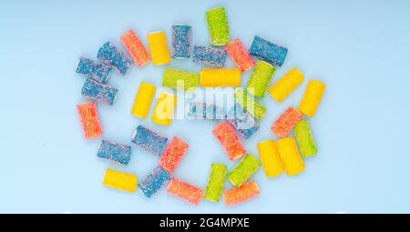 Bonbons délicieux multicolores sur fond rose et turquoise Banque D'Images