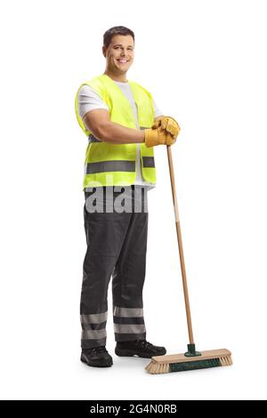 Portrait complet d'un jeune homme nettoyant dans un uniforme tenant un balai isolé sur fond blanc Banque D'Images