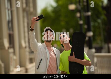 Deux amis masculins prennent de grands selfies ensemble Banque D'Images