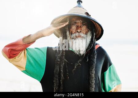 Portrait de l'ancien rastafari avec des dreadlocks regardant l'appareil photo dans la nature avec fond blanc Banque D'Images